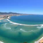 Panoramiczny widok na plażę La Concha w San Sebastian z charakterystycznym półksiężycowym kształtem zatoki i górami w tle